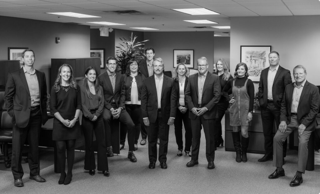 Black and white image of the full Woodley Farra Manion team.